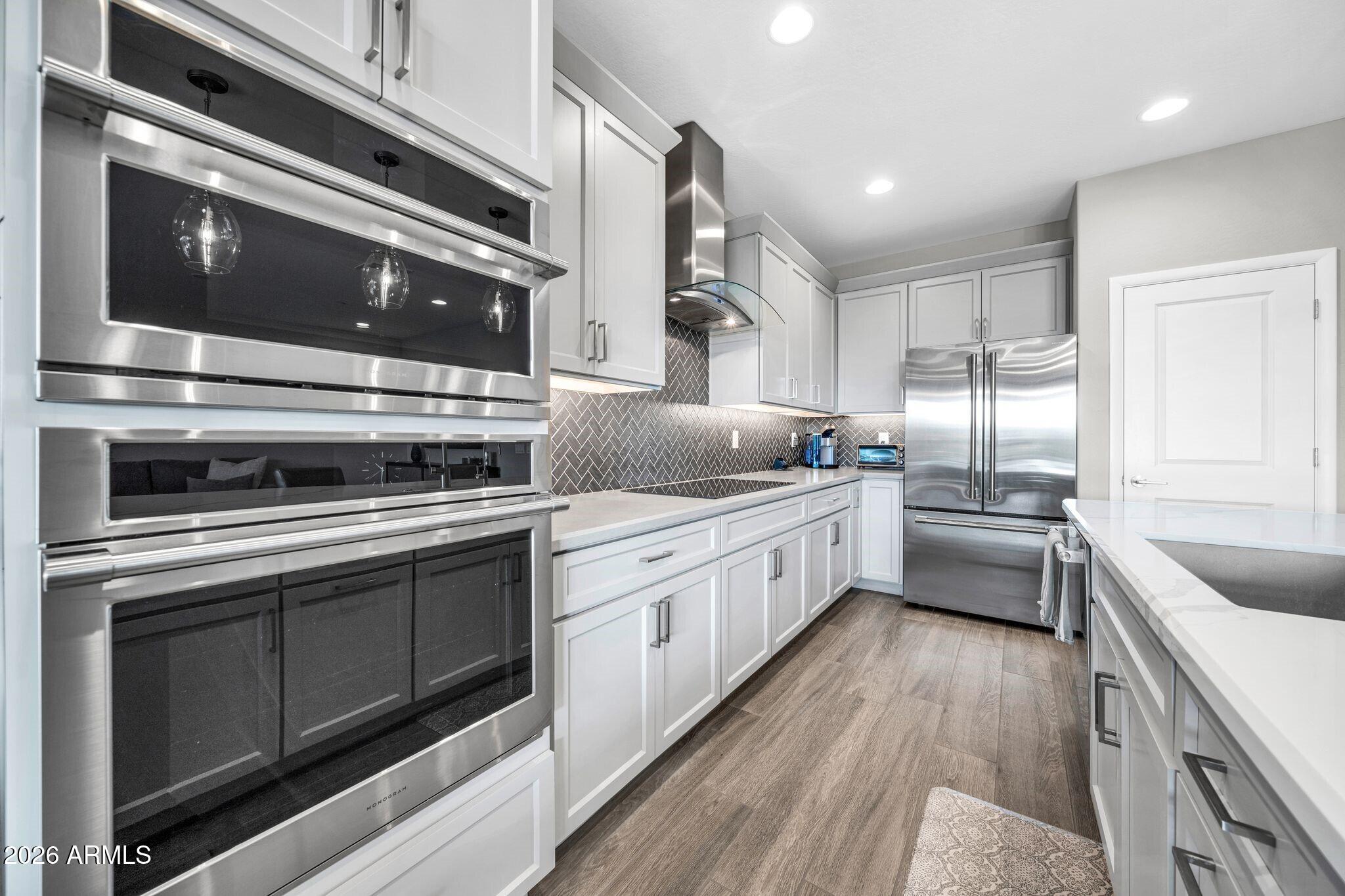17501 East Cindercone Road Rio Verde, AZ 85263 - Photo 7 of 43 a kitchen with stainless steel appliances kitchen island granite countertop a stove a sink and a microwave