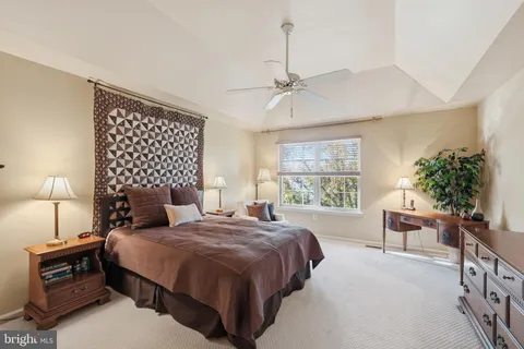 a spacious bedroom with a bed a lamp and potted plant