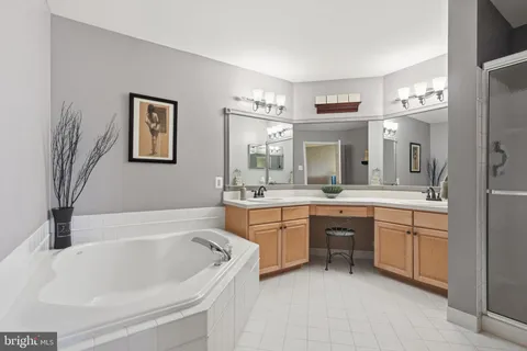 a bathroom with a tub a sink double vanity and a window