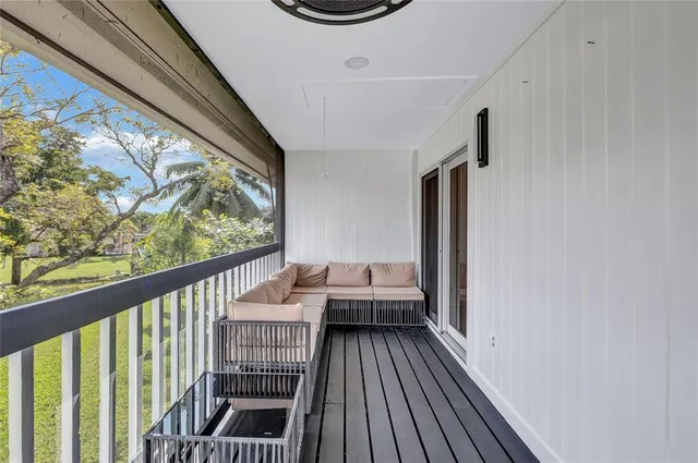 a view of a hallway with wooden floor and windows