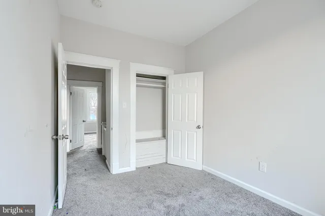 an empty room with closet and a bathroom