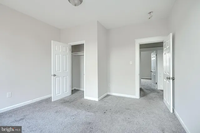a view of an empty room with closet and a window