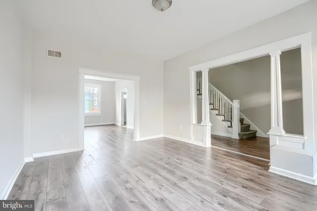 a view of empty room with wooden floor
