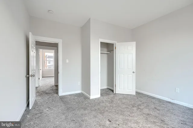 a view of a room with a hallway and closet