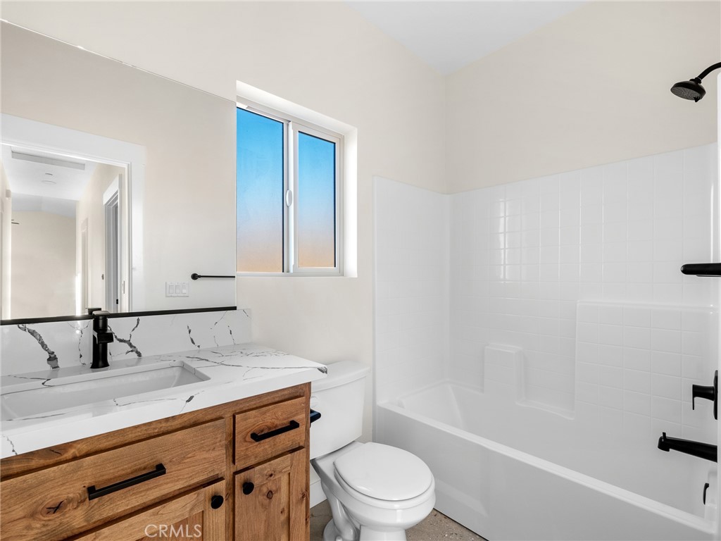 16173 Pela Road Apple Valley, CA 92307 - Photo 13 of 36 a bathroom with a granite countertop sink a toilet and shower