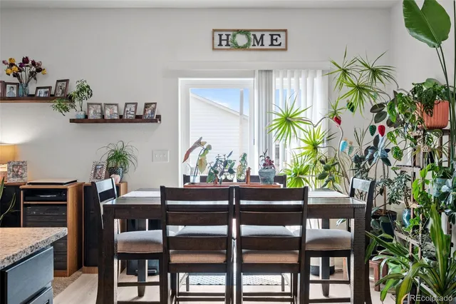 a dining room with furniture and a potted plant