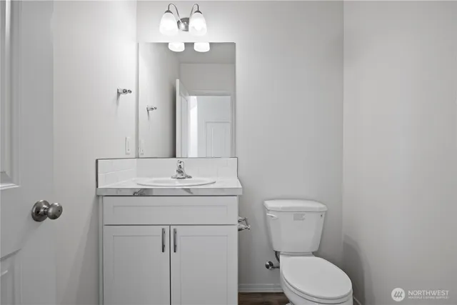 a bathroom with a toilet a sink and mirror