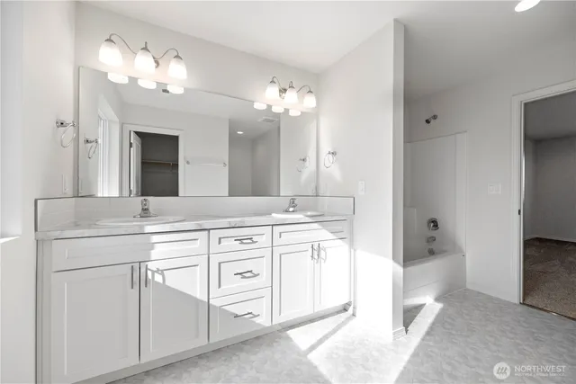 a spacious bathroom with a double vanity sink and a mirror