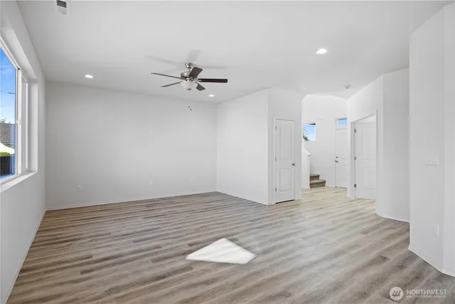 a view of an empty room with a window and a ceiling fan