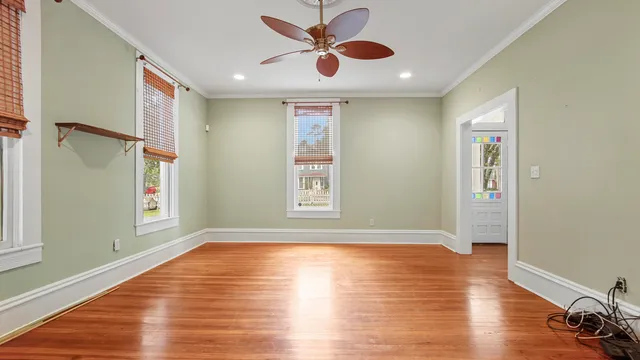 a view of an empty room with window and wooden floor