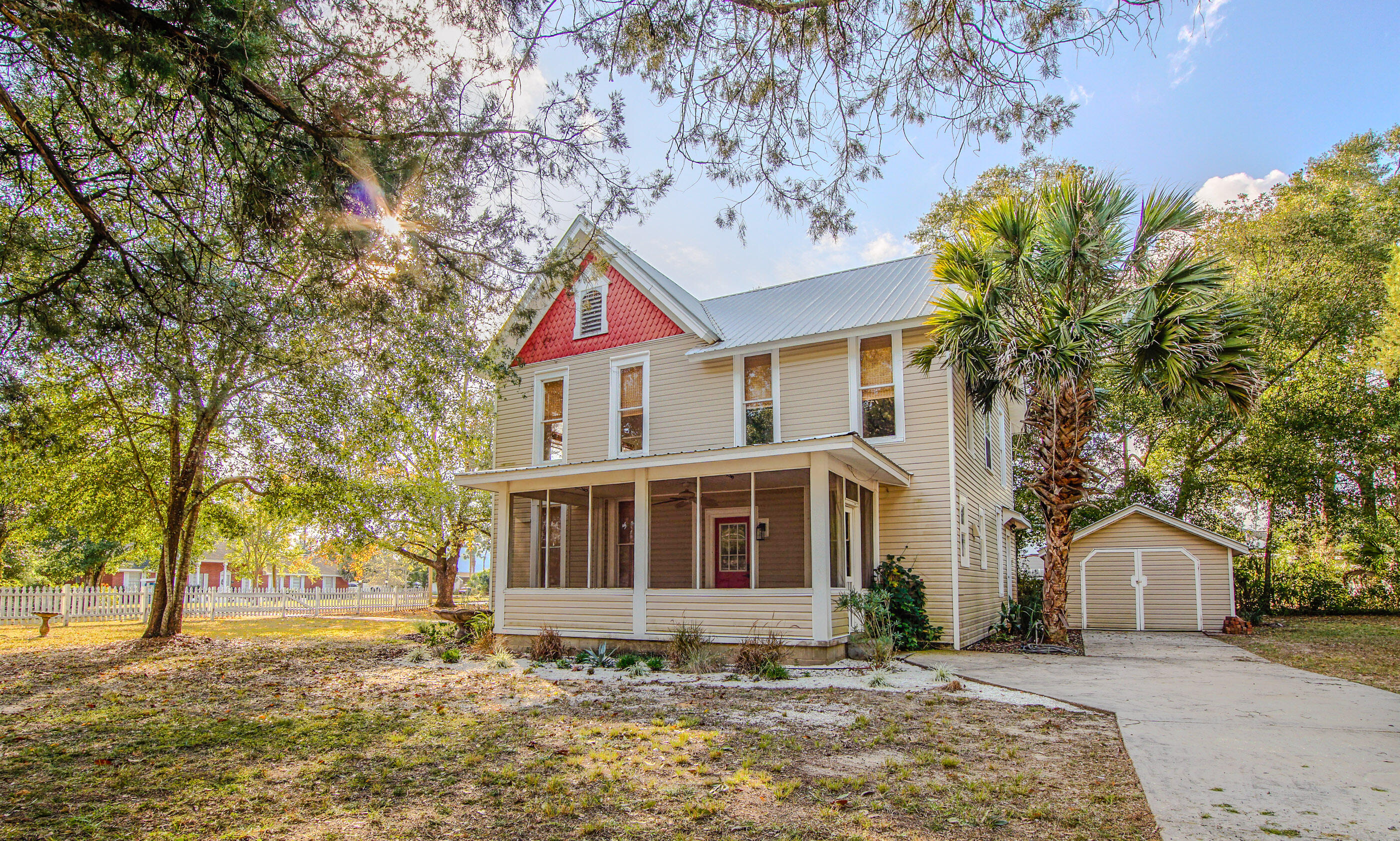 87 Bay Avenue DeFuniak Springs, FL 32435 - Photo 3 of 55 a front view of a house with a yard covered with snow and trees