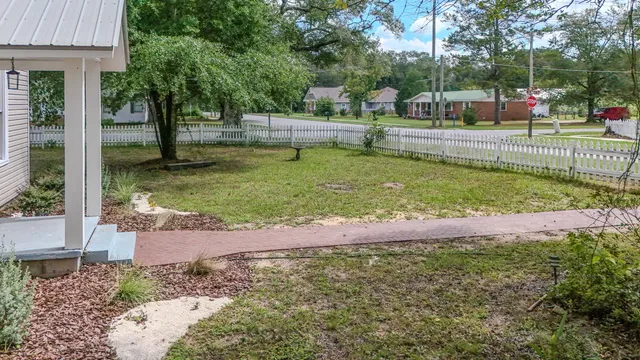 a view of a yard with plants and trees