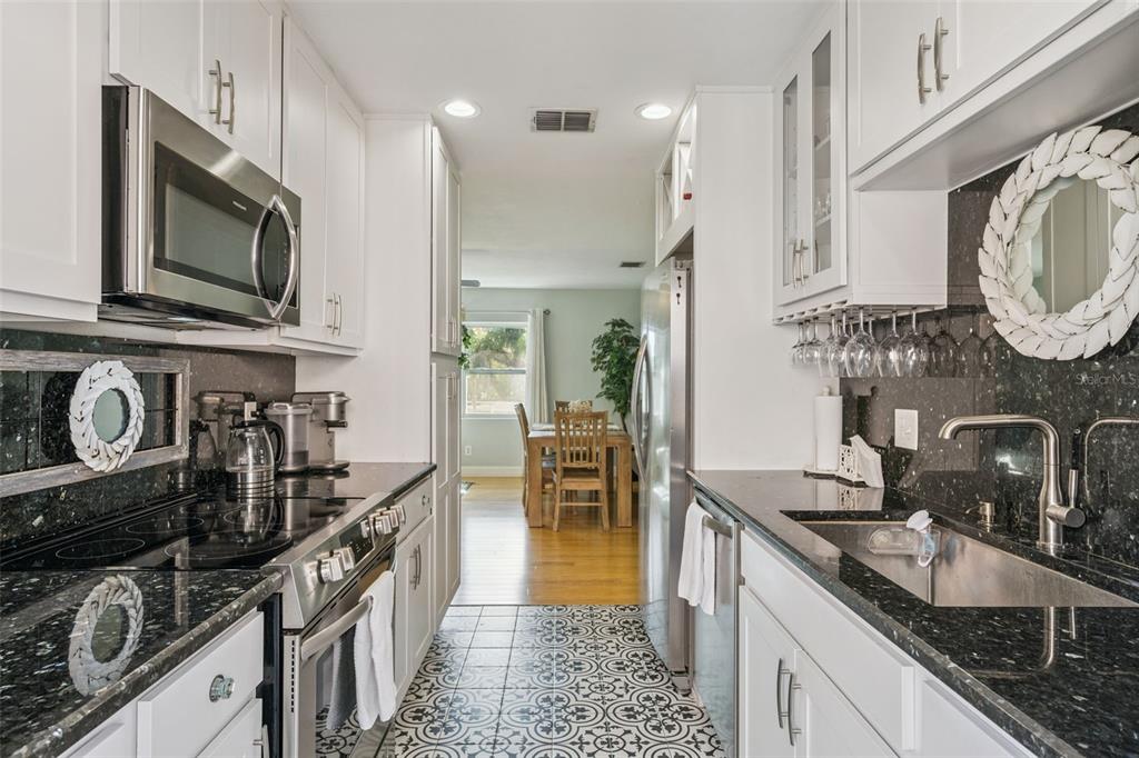 124 East Harding Street Orlando, FL 32806 - Photo 8 of 21 a kitchen with granite countertop a sink a stove and cabinets