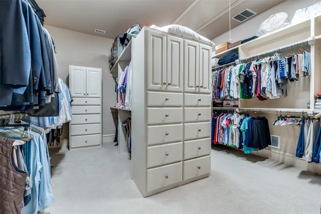 a view of walk in closet with clothes and shoes