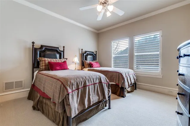 a bed sitting in a bedroom next to a window and a chandelier