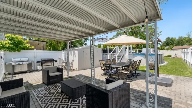 a patio with a table and chairs with a barbeque grill