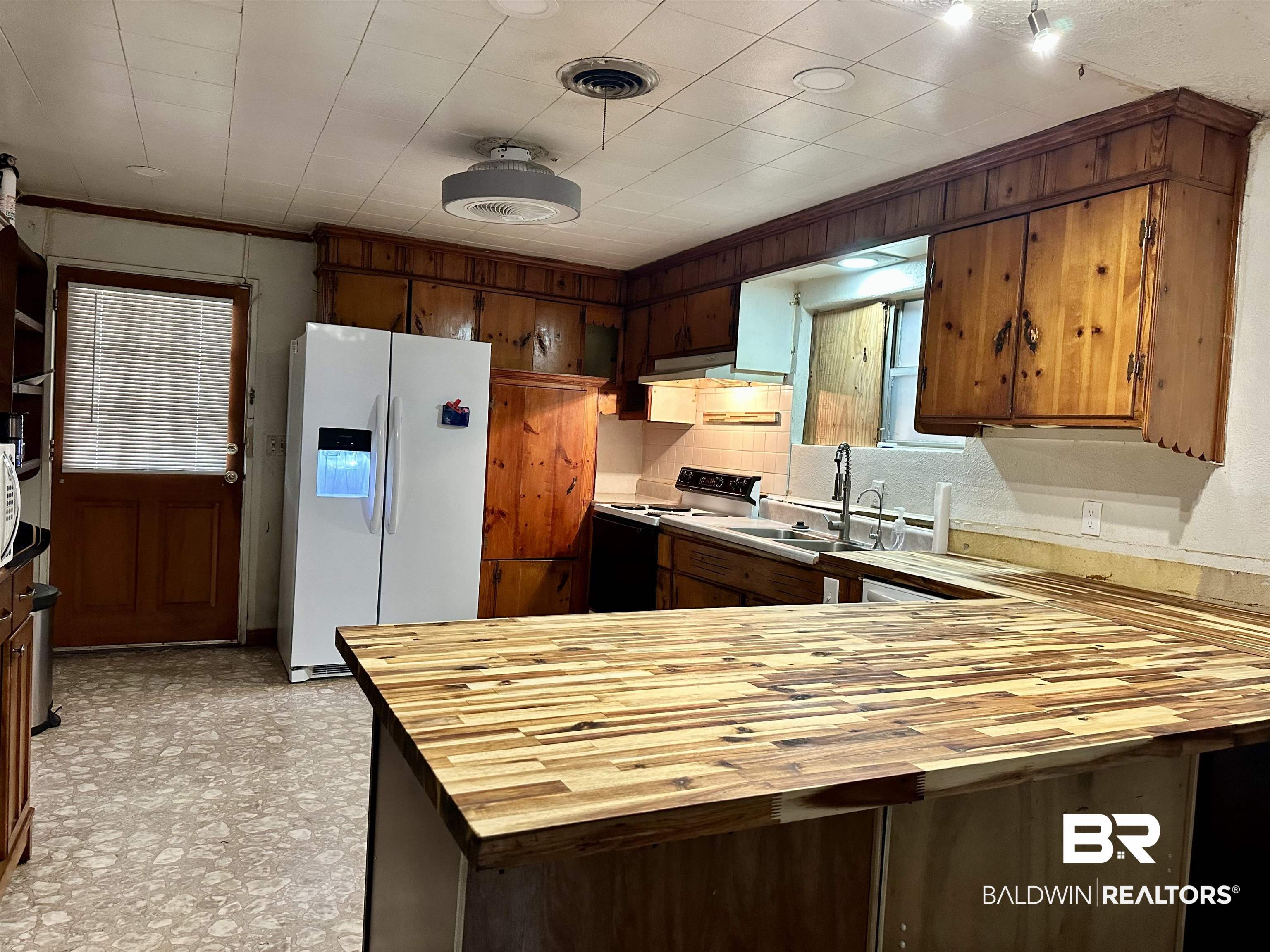 1206 St Nicholas Avenue Brewton, AL 36426 - Photo 3 of 19 Kitchen featuring range with electric stovetop, kitchen peninsula, sink, white refrigerator with ice dispenser, and tasteful backsplash