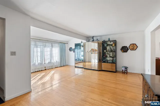 a view of an empty room with closet and windows