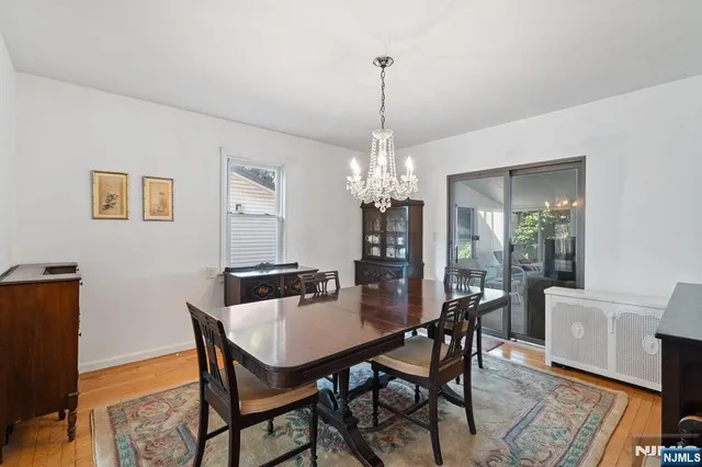 a view of a dining room with furniture a chandelier and wooden floor