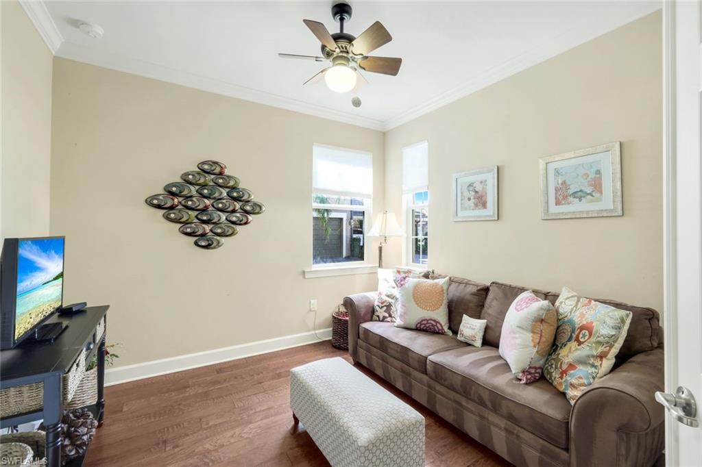 9532 Ironstone Terrace, Unit 102 Naples, FL 34120 - Photo 17 of 45 Living area with wood finished floors, ornamental molding, and ceiling fan