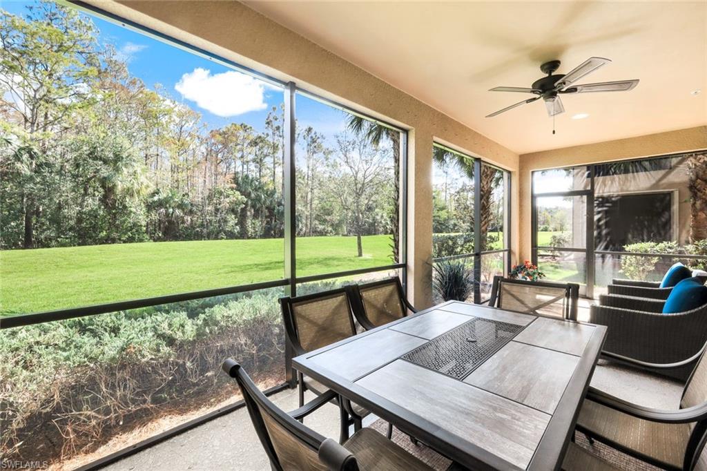 9532 Ironstone Terrace, Unit 102 Naples, FL 34120 - Photo 18 of 45 Sunroom / solarium with a ceiling fan, view of wooded area, and outdoor dining space