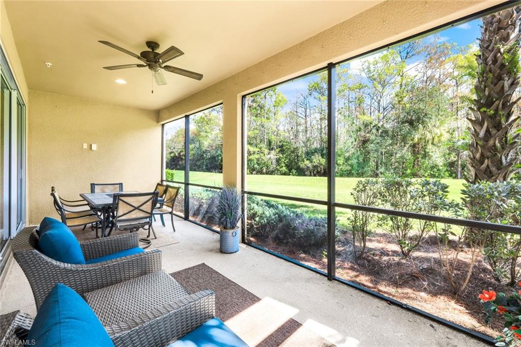9532 Ironstone Terrace, Unit 102 Naples, FL 34120 - Photo 19 of 45 Sunroom / solarium with ceiling fan, view of wooded area, and outdoor dining area