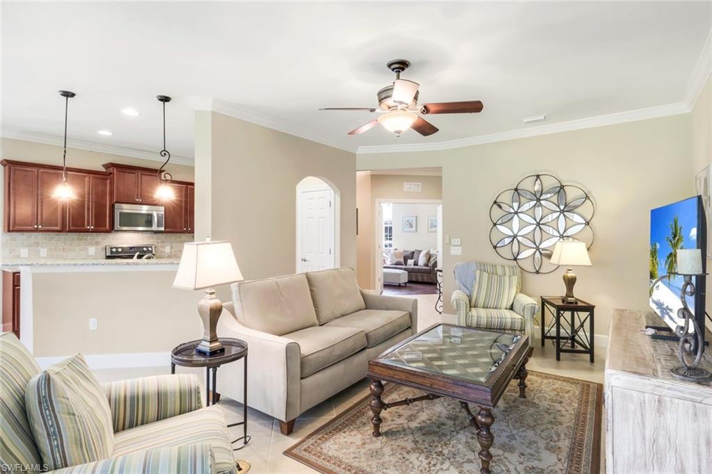 9532 Ironstone Terrace, Unit 102 Naples, FL 34120 - Photo 3 of 45 Living area with a ceiling fan, arched walkways, and crown molding