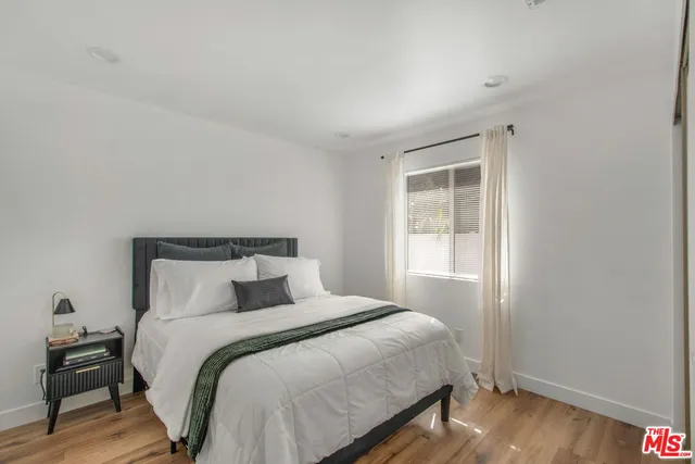 a bedroom with a bed and wooden floor