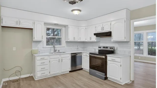 an empty room with wooden floor a ceiling fan and a bathroom