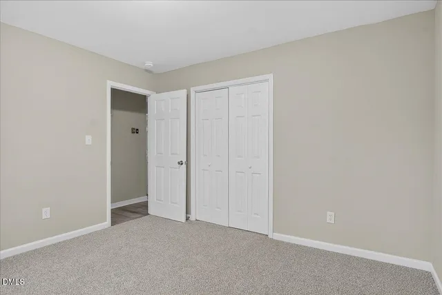an empty room with chandelier fan