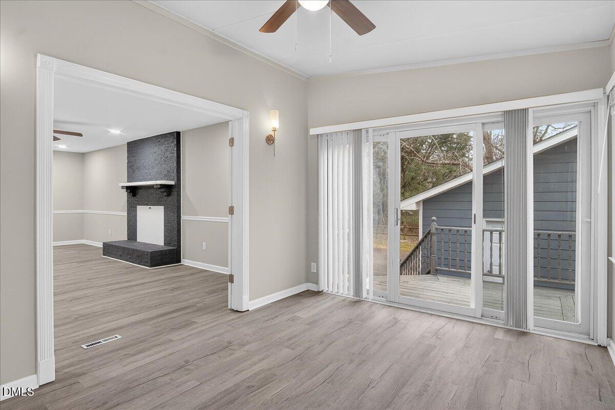 13013 Meadow Ridge Drive Rougemont, NC 27572 - Photo 6 of 27 an empty room with wooden floor a ceiling fan and a bathroom