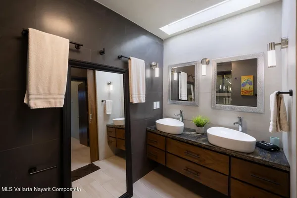 a bathroom with a granite countertop sink and a mirror