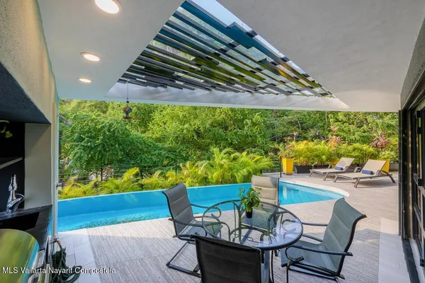 a view of a chairs and table in patio with a yard