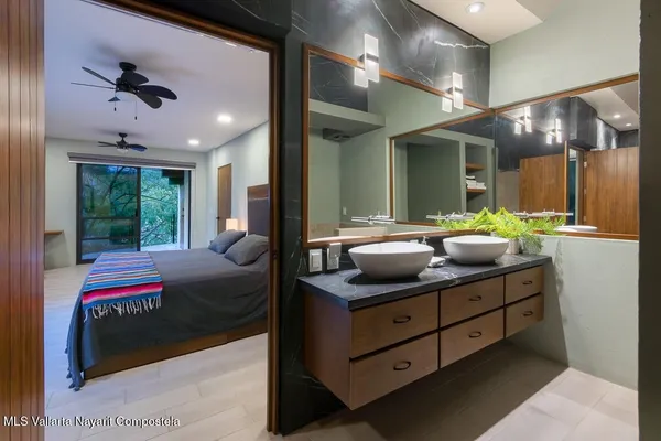 a bedroom with a bed and a large mirror