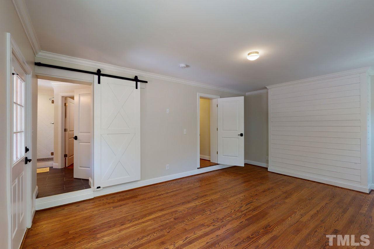 1304 Dixie Trail Raleigh, NC 27607 - Photo 12 of 26 a view of an empty room with wooden floor and a bathroom