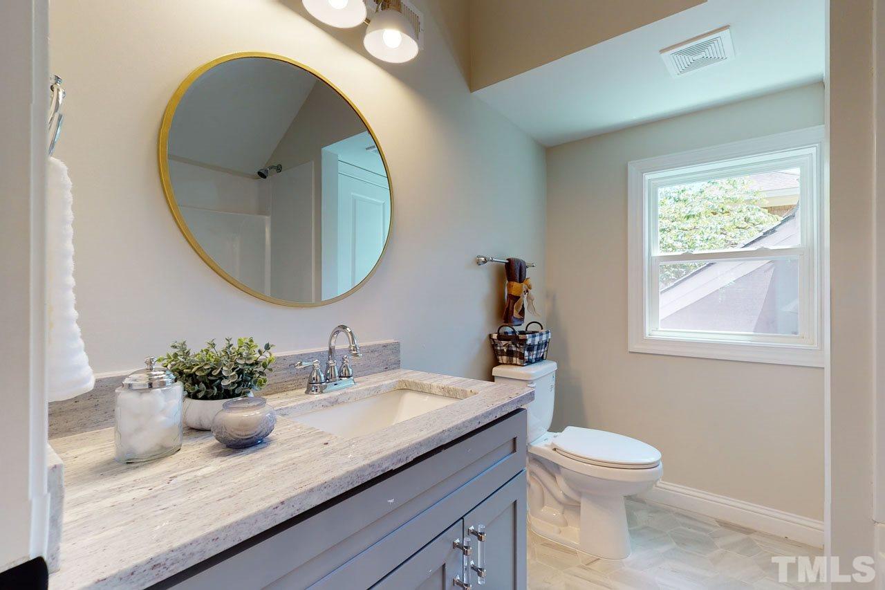 1304 Dixie Trail Raleigh, NC 27607 - Photo 17 of 26 a bathroom with a granite countertop sink and a mirror