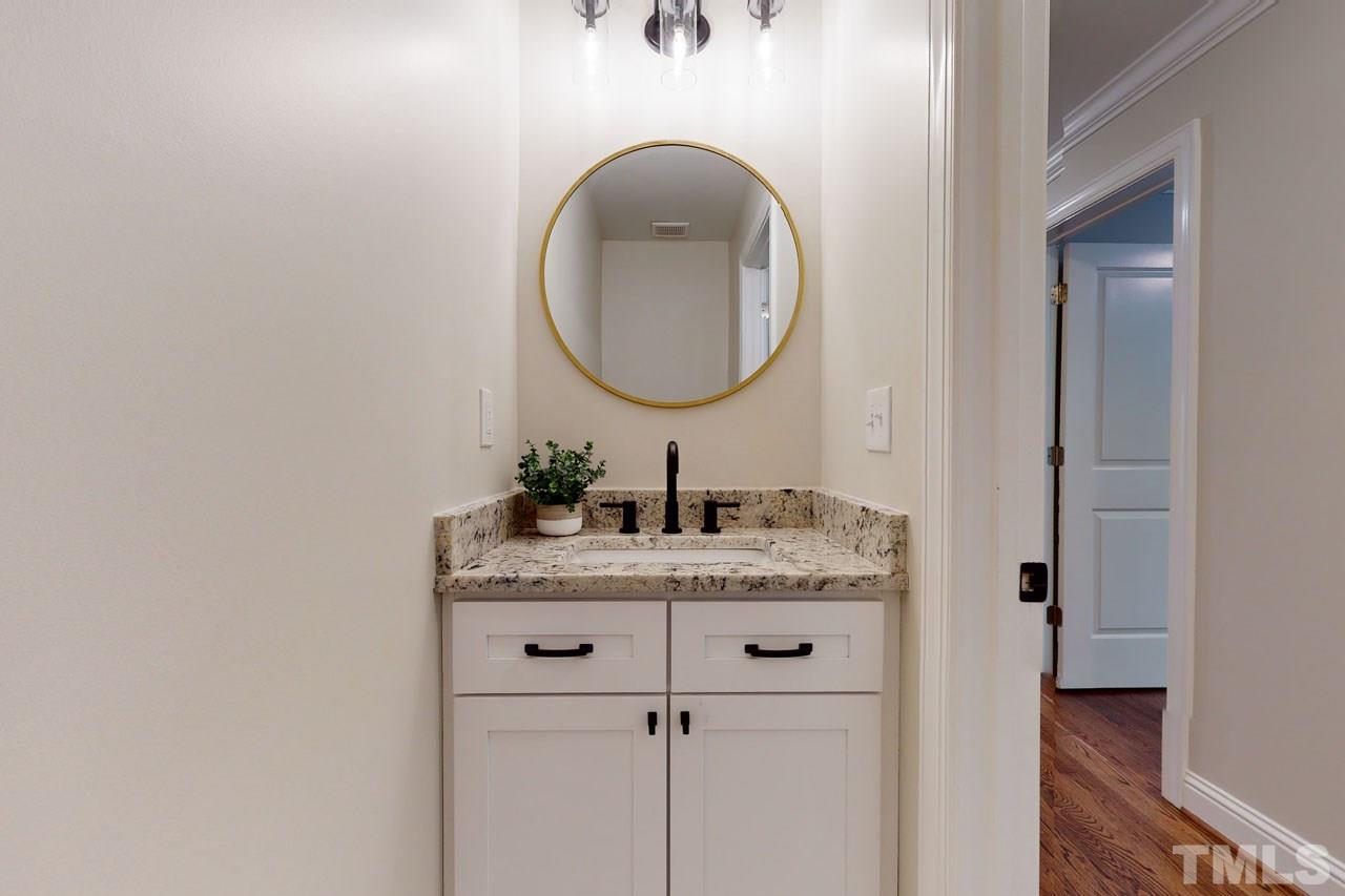 1304 Dixie Trail Raleigh, NC 27607 - Photo 10 of 26 a bathroom with a granite countertop sink and a mirror
