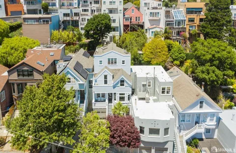 front view of a house with a yard and potted plants