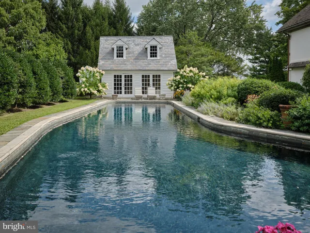 an aerial view of a residential houses with outdoor space and trees