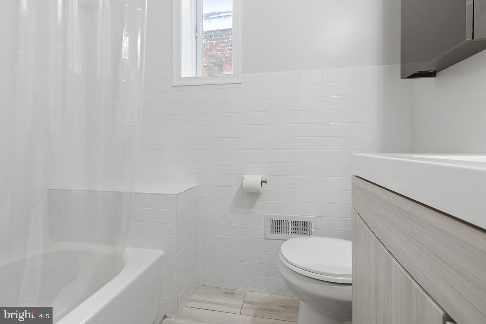 5213 Rodman Street Philadelphia, PA 19143 - Photo 26 of 31 a white toilet sitting next to a bath tub