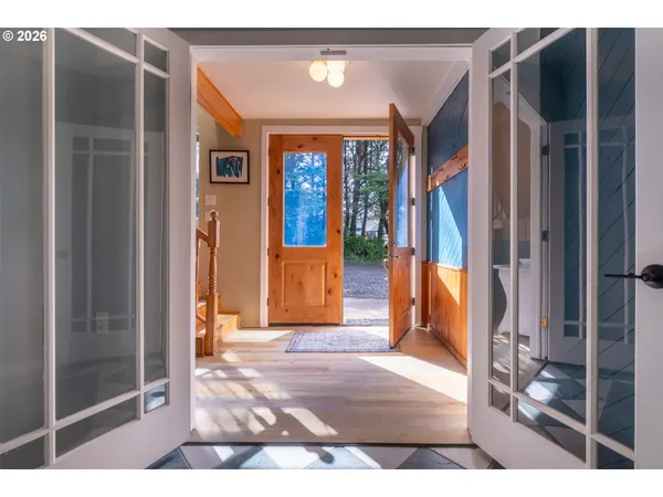 a view of a hallway with wooden floor and a living room