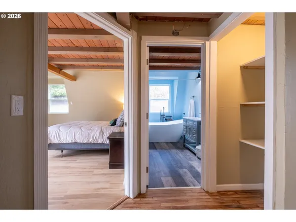 a spacious bedroom with a bed and wooden floor