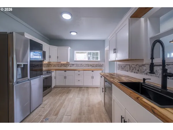 a kitchen with granite countertop a sink cabinets and stainless steel appliances