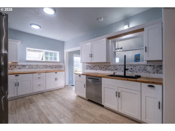 a kitchen with stainless steel appliances granite countertop a refrigerator and a stove top oven
