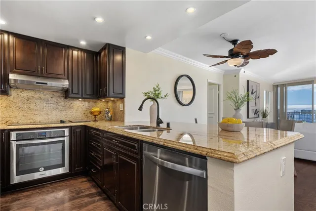 a kitchen with stainless steel appliances granite countertop a sink a stove and a refrigerator