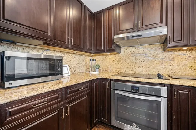 a kitchen with granite countertop wood cabinets and stainless steel appliances
