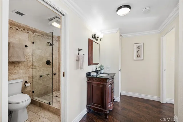 a bathroom with a granite countertop toilet a sink and shower