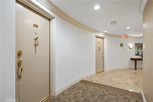 a view of a hallway with wooden floor and a bathroom