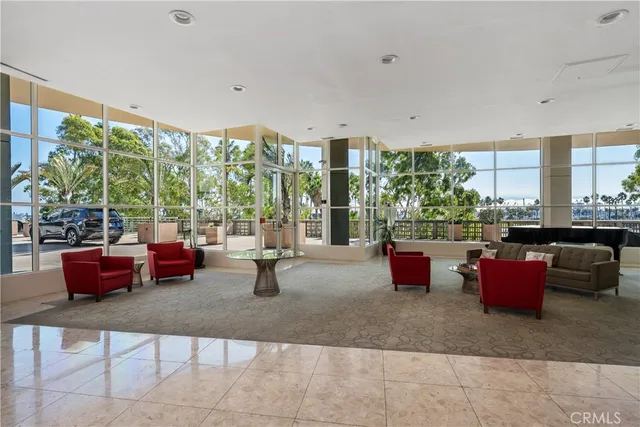 a living room with patio furniture and floor to ceiling window