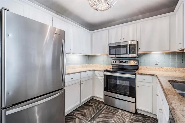 a kitchen with stainless steel appliances a refrigerator sink and microwave